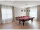 Bright game room with hardwood floors, a billiard table, and large windows adorned with elegant curtains at 5305 Brookgrove Dr, Sarasota, FL 34238