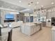 Open-concept kitchen with a large island, stainless steel appliances, and pendant lighting that flows into living area at 5305 Brookgrove Dr, Sarasota, FL 34238