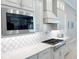 Modern kitchen featuring diamond backsplash, stainless steel appliances, and custom hood at 5305 Brookgrove Dr, Sarasota, FL 34238