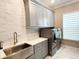 Well-organized laundry room with gray cabinetry, quartz countertops, and modern washer and dryer units at 5305 Brookgrove Dr, Sarasota, FL 34238