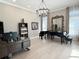 Spacious living room showcases two pianos, hardwood floors, a chandelier and neutral paint at 5305 Brookgrove Dr, Sarasota, FL 34238