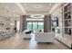 Bright, open-concept living room with modern chandelier, fireplace, and access to outdoor pool at 5305 Brookgrove Dr, Sarasota, FL 34238