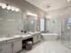 Lavish bathroom features a dual sink vanity, freestanding tub, and modern lighting at 5305 Brookgrove Dr, Sarasota, FL 34238