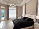 Light-filled main bedroom with a door to the pool area, tray ceiling, and sleek furniture at 5305 Brookgrove Dr, Sarasota, FL 34238