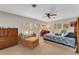 Bright bedroom featuring a ceiling fan, shuttered windows, and a comfortable chaise lounge chair at 5376 Shadow Lawn Dr, Sarasota, FL 34242