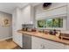 Functional kitchen with light countertops, white cabinetry and a sunlit window at 5376 Shadow Lawn Dr, Sarasota, FL 34242