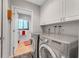 Laundry room with modern washer and dryer, built in cabinets and tile flooring at 5376 Shadow Lawn Dr, Sarasota, FL 34242