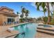 Private pool and jacuzzi with waterfront views, palm trees, and blue lounge furniture at 5376 Shadow Lawn Dr, Sarasota, FL 34242