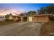Inviting single-story home exterior with a well-maintained driveway and lush landscaping at dusk at 5402 Shadow Lawn Dr, Sarasota, FL 34242