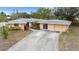 Exterior shot of the home showcasing the front yard, driveway, and landscaping at 5402 Shadow Lawn Dr, Sarasota, FL 34242
