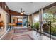 Bright sun room with tile floors, wood paneling, ceiling fan, and large windows overlooking the lush backyard at 5402 Shadow Lawn Dr, Sarasota, FL 34242