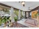 Bright and airy sun room featuring tile flooring, wood paneling, large windows and views of lush greenery at 5402 Shadow Lawn Dr, Sarasota, FL 34242