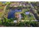 Expansive aerial view of a serene property featuring a large pond, lush greenery, and charming homes at 5645 Churchill Downs Rd, Sarasota, FL 34241