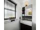 Modern bathroom with a sleek vanity, decorative mirror, and window at 5645 Churchill Downs Rd, Sarasota, FL 34241