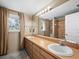 Bathroom featuring double sinks and large mirror with vanity lighting at 5645 Churchill Downs Rd, Sarasota, FL 34241
