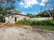 Charming one-story home with neutral siding and a brown front door adorned with a welcoming wreath at 5645 Churchill Downs Rd, Sarasota, FL 34241