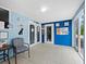Bright hallway with double doors, blue walls, and tile flooring, providing a clean and accessible space at 5645 Churchill Downs Rd, Sarasota, FL 34241