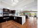 Modern, open-concept kitchen with dark cabinetry, stainless steel appliances, and hardwood floors at 5645 Churchill Downs Rd, Sarasota, FL 34241