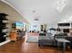 Open-concept living room with hardwood floors, gray sectional, and large-screen TV at 5645 Churchill Downs Rd, Sarasota, FL 34241