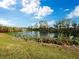 Scenic view of a peaceful pond with a fountain and lush vegetation at 5645 Churchill Downs Rd, Sarasota, FL 34241