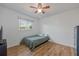 Cozy bedroom with wood floors, a ceiling fan, and a window offering natural light at 625 Ennis Nw Ter, Port Charlotte, FL 33952