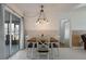 Dining area featuring stylish light fixture, wood-look accent wall, and a sliding glass door at 625 Ennis Nw Ter, Port Charlotte, FL 33952
