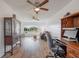 Bright living room featuring hardwood floors, a ceiling fan, and a desk with computer at 625 Ennis Nw Ter, Port Charlotte, FL 33952