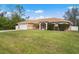 Well-manicured lawn and shrubbery framing a single story home and a two car garage at 1577 Taggard Rd, North Port, FL 34288