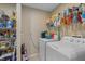 Functional laundry room with storage shelves, washer, dryer, and neutral walls at 1577 Taggard Rd, North Port, FL 34288
