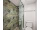 Modern bathroom featuring glass door shower with decorative leaf tile and updated fixtures at 1751 Beach Rd # 404, Englewood, FL 34223