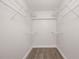 Walk-in closet featuring plenty of shelving space and vinyl plank flooring at 1751 Beach Rd # 404, Englewood, FL 34223