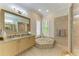 Bright bathroom featuring a soaking tub, walk-in shower, and double vanity at 22623 Morning Glory Cir, Bradenton, FL 34202
