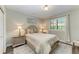 Comfortable bedroom featuring a queen-sized bed, nightstands, and a window with plantation shutters at 22623 Morning Glory Cir, Bradenton, FL 34202