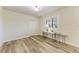 Minimalist bedroom with wood flooring, a desk, and a window with white shutters at 22623 Morning Glory Cir, Bradenton, FL 34202