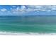 Calm ocean view showing clear turquoise water meeting the white sandy beach under a blue sky dotted with fluffy clouds at 2601 Gulf N Dr # B16, Bradenton Beach, FL 34217