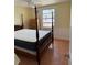 Well-lit bedroom showcasing tiled floor, a four poster bed, and a window bringing in plenty of light at 2601 Gulf N Dr # B16, Bradenton Beach, FL 34217