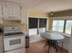 Well-lit kitchen features white appliances and cabinets, complemented by a charming eat-in table at 2601 Gulf N Dr # B16, Bradenton Beach, FL 34217