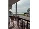 Inviting front porch with wicker seating, steps, and stunning water views beyond a palm tree at 2601 Gulf N Dr # B16, Bradenton Beach, FL 34217