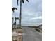 Scenic water view from a driveway, surrounded by lush palm trees and landscape at 2601 Gulf N Dr # B16, Bradenton Beach, FL 34217