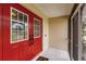 Charming red double front doors open to a screened front porch entrance at 27425 Jones Loop Rd, Punta Gorda, FL 33982
