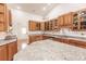 Spacious kitchen featuring granite counters, tile backsplash, and wood cabinets at 27425 Jones Loop Rd, Punta Gorda, FL 33982
