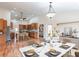 View of kitchen and dining room with wood floors, stainless appliances, and a dining table set for a meal at 27425 Jones Loop Rd, Punta Gorda, FL 33982