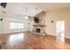 Bright living room featuring a stone fireplace, hardwood floors, and a ceiling fan at 27425 Jones Loop Rd, Punta Gorda, FL 33982