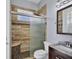 Bathroom featuring granite countertops, new wood-look tiles, and glass shower doors at 4708 Clipper Dr, Bradenton, FL 34208