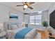 Bright bedroom with hardwood floors, ceiling fan, and a comfy queen-size bed with white and blue decor at 4708 Clipper Dr, Bradenton, FL 34208