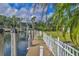 Waterfront property featuring a private dock with a charming covered boat lift, surrounded by lush landscaping at 4708 Clipper Dr, Bradenton, FL 34208