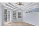 Bright living room with tray ceiling, ceiling fan, and access to the lanai at 4708 Clipper Dr, Bradenton, FL 34208