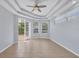 Bright living room with tray ceiling, ceiling fan, and access to the lanai at 4708 Clipper Dr, Bradenton, FL 34208