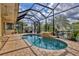 Gorgeous in-ground pool with a waterfall feature and brick paver deck inside a screened enclosure at 4708 Clipper Dr, Bradenton, FL 34208