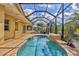 Beautiful in-ground pool inside screened enclosure, brick pavers, and tropical plants at 4708 Clipper Dr, Bradenton, FL 34208